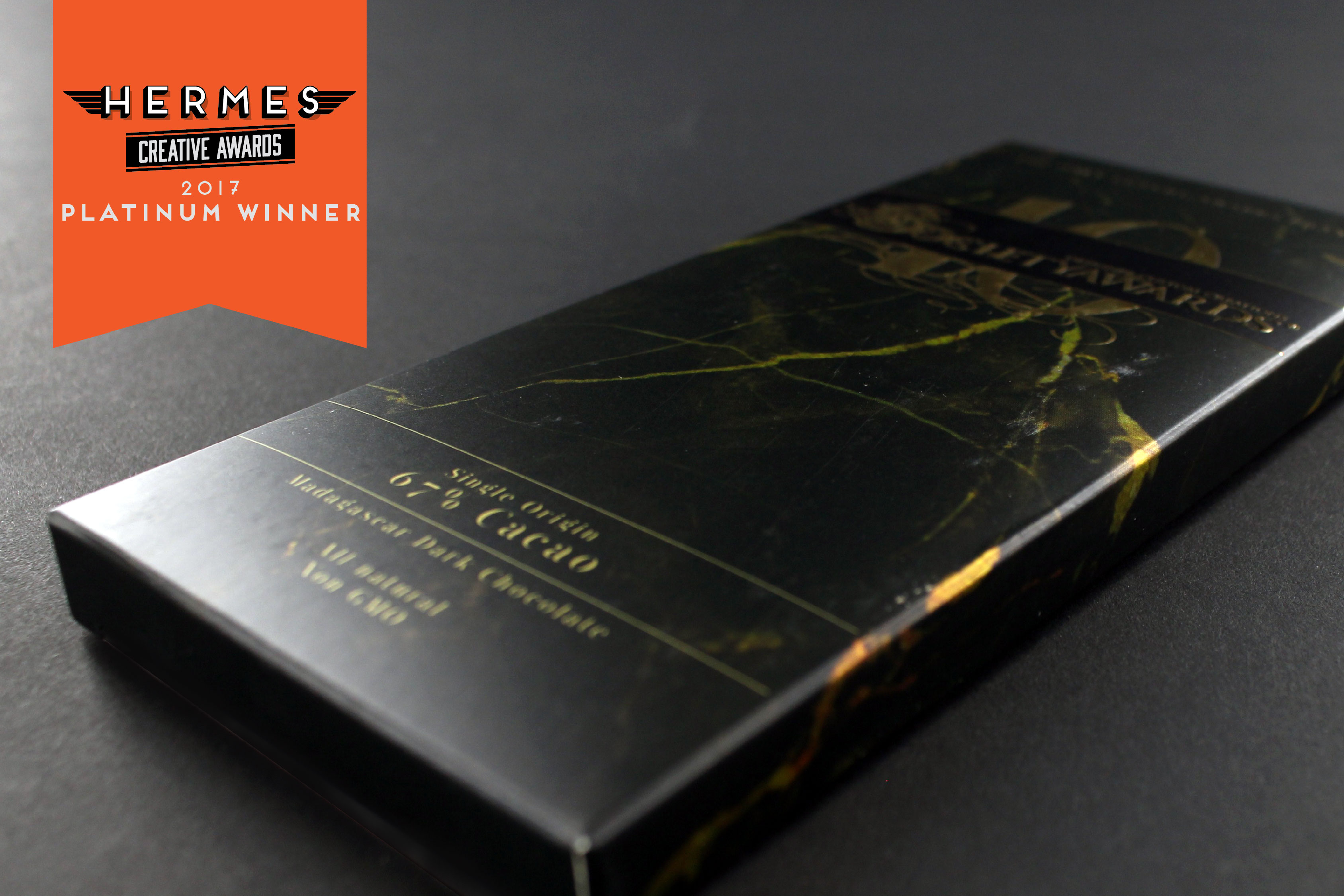 Chocolate bar box from the Society Awards 10 Year Chocolate. Box uses metallic paperboard, metallic ink, custom graphics, gold foil